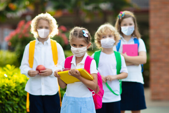 Des enfants portant le masque en route pour l'école